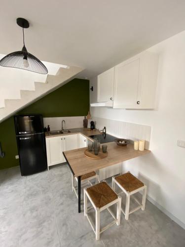 cocina con mesa de madera y nevera negra en La Casita Luz, en Cavaillon