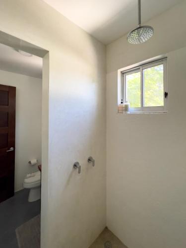 a bathroom with a shower and a window and a toilet at Salt Nosara in Nosara