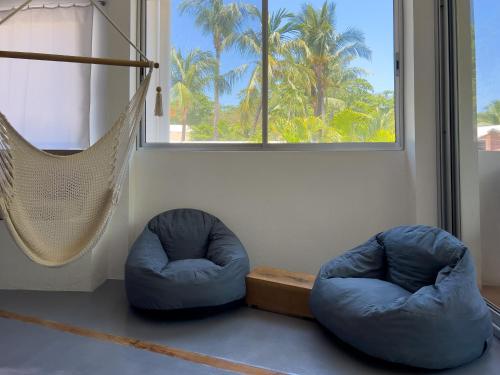 two blue bean bags in a room with a hammock at Salt Nosara in Nosara