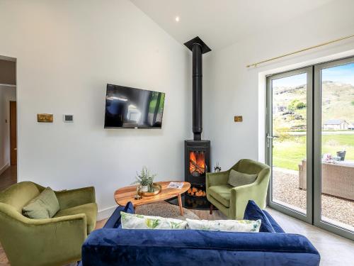 a living room with a couch and chairs and a fireplace at The Stables in Littleborough