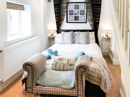a bedroom with a bed and a chair at Keepers Cottage in Docking