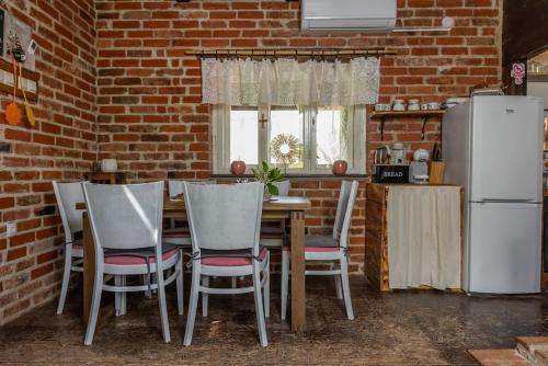 a kitchen with a table and chairs and a brick wall at Kuća za odmor Kleopatra in Netretić