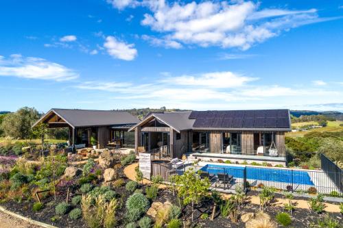 a house with a solar roof and a pool at Obsidian View Lodge in Putiki