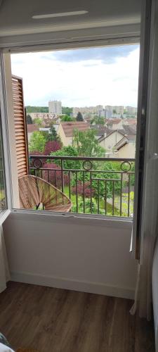 a large window with a view of a city at Calme et verdure à Poissy 50 m2 parking terrasse in Poissy