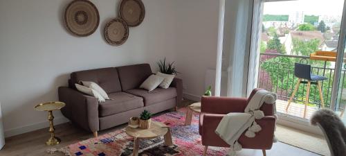 a living room with a couch and a balcony at Calme et verdure à Poissy 50 m2 parking terrasse in Poissy