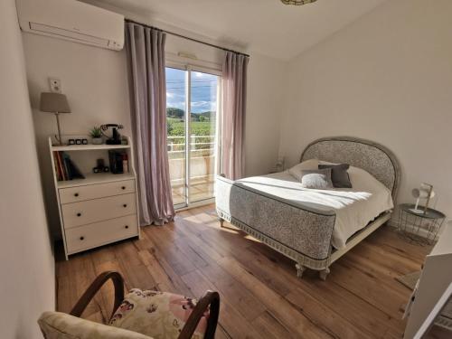 ein Schlafzimmer mit einem Bett und einem großen Fenster in der Unterkunft La Chambre du Saunei in Castelnau-de-Guers