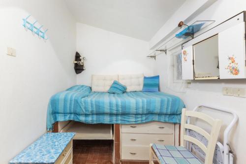 um pequeno quarto com uma cama e uma cadeira em VILLETTA L'ARANCIO em Marina di Campo