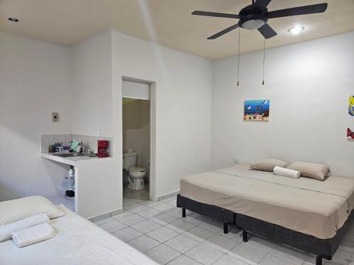 a bedroom with two beds and a ceiling fan at El Padrino in Akumal