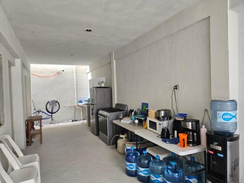 a room with a kitchen with a counter with bottles of water at El Padrino in Akumal