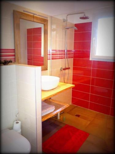 La salle de bains rouge est pourvue d'un lavabo et d'une douche. dans l'établissement NEW Villa with JACUZZI, near St Cyprien beach, à Lecci