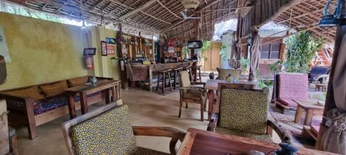 a restaurant with tables and chairs in a room at Salama & Mbuyuni Bungalows in Matemwe