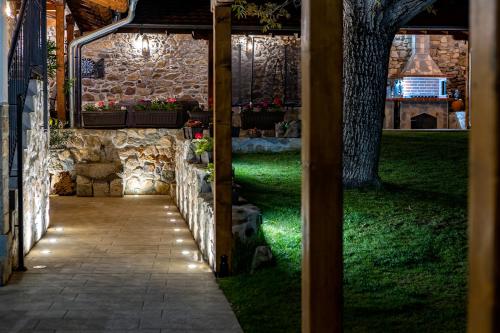 a pathway leading to a stone building with lights at Къща за приятели Недкови in Vasil Levski