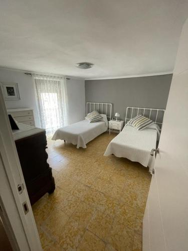 a white room with two beds and a piano at Cal Robert in Penellas