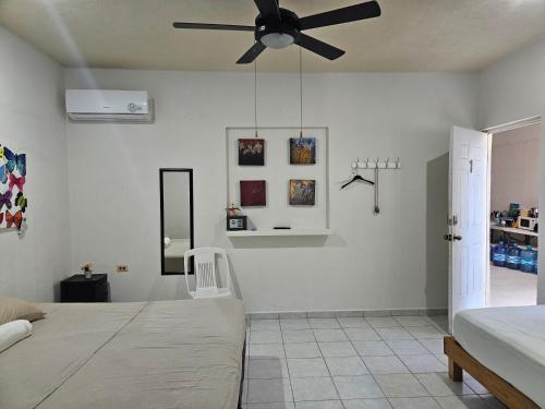 a bedroom with a bed and a ceiling fan at El Padrino in Akumal