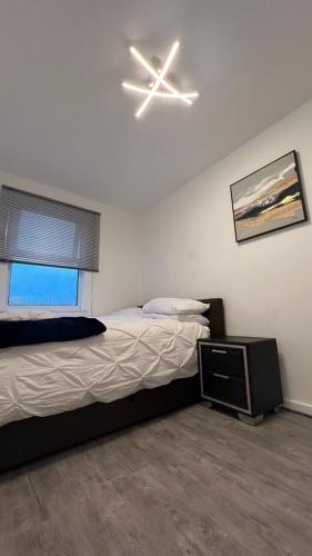 a bedroom with a bed and a ceiling fan at Buzz Crib in London