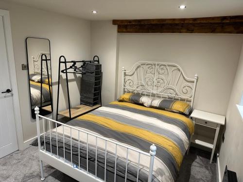 um quarto com uma cama com uma cabeceira de metal em Chatsworth stables em Newbold