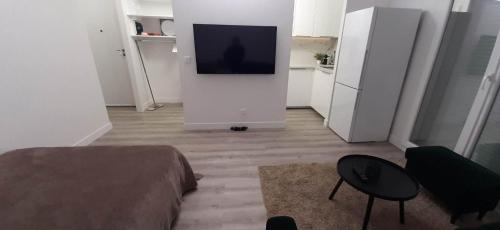 uma sala de estar com um sofá e uma televisão de ecrã plano em Magnifique Studio de 25 m2 em Paris