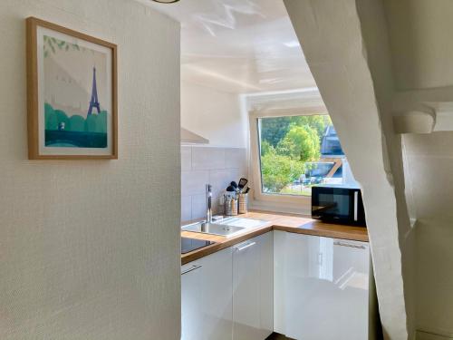 une cuisine avec un évier et une fenêtre dans l'établissement F2 Le City Parking Netflix Wifi Gare, à Évreux