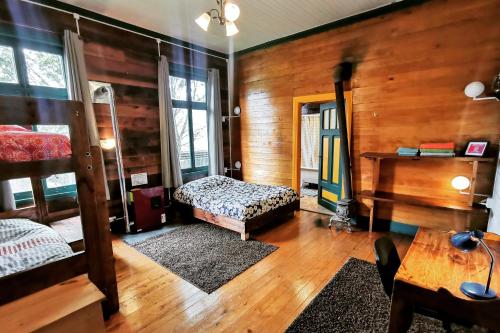 a bedroom with two bunk beds and a piano at MaPatagonia Hostel Casa Patrimonial in Puerto Varas