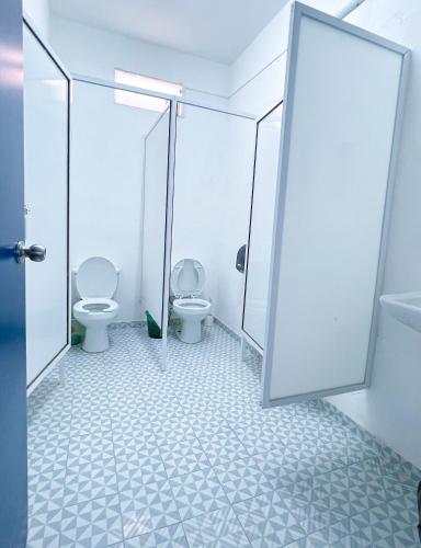 a bathroom with two toilets and a mirror at Vive Alegria Hostel in Puerto Vallarta