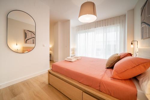 een slaapkamer met een groot oranje bed en een spiegel bij Acogedor apartamento en centro histórico Malaga in Málaga