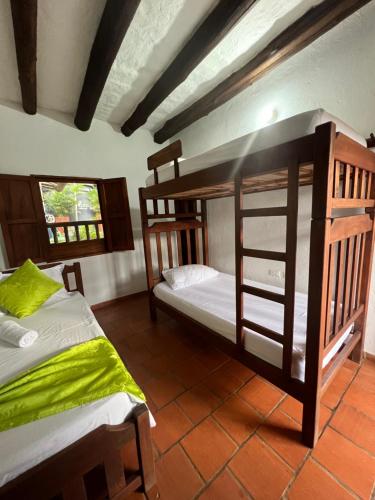 a bedroom with two bunk beds and a window at Hostal Villa San Rafael in Barichara