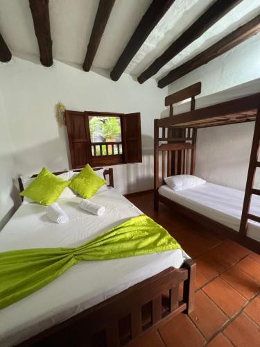 a bedroom with two bunk beds and a window at Hostal Villa San Rafael in Barichara