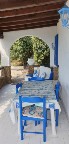 a blue table and chairs on a patio at Sundowner Home in Marongiu