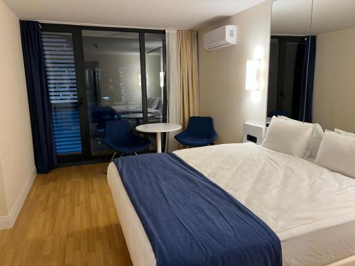 een hotelkamer met een bed en een tafel en stoelen bij orbi cyti batumi in Batoemi