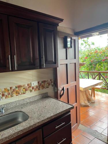 a kitchen with a sink and a door to a patio at Hostal Villa San Rafael in Barichara