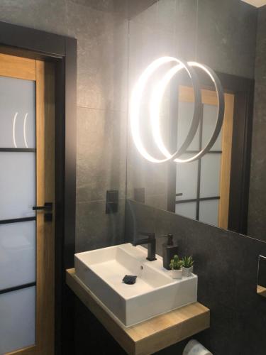 a bathroom with a white sink and a mirror at Apartamenty Premium Loft in Wadowice