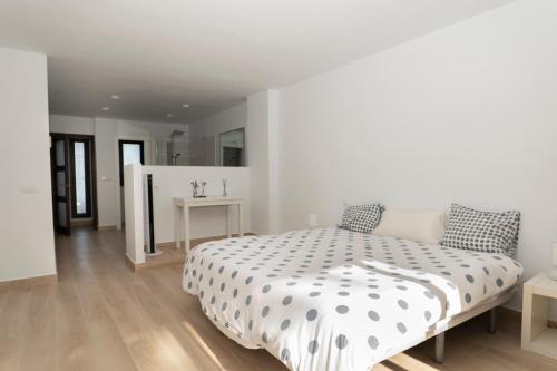 um quarto branco com uma cama e uma mesa em Spacious Duplex with garden in Sotogrande em Sotogrande