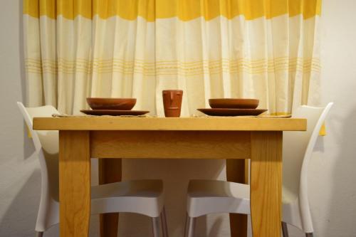 a wooden table with bowls and cups on it at ¡Hermosa Estancia Centro de Oaxaca! in Oaxaca City