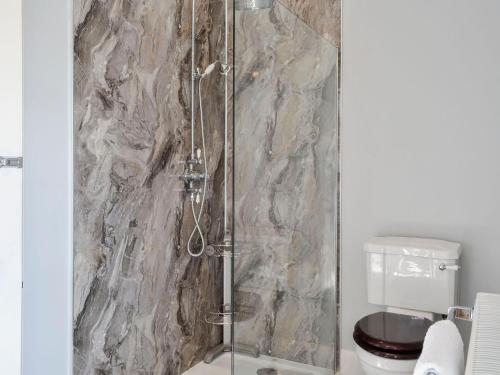 a bathroom with a glass shower with a toilet at Craigvar House in Castle Douglas