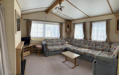 a living room with a couch and a tv at Marsh Farm Holiday Park in Great Yarmouth