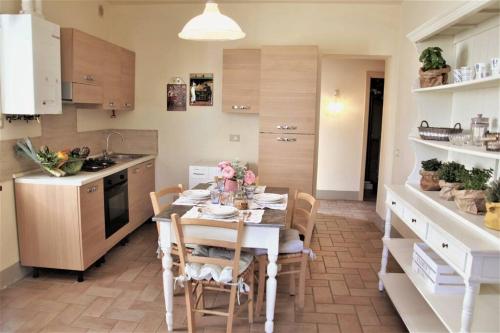 a kitchen with a table and chairs in a room at CLAUDIA VACANZA TOSCANA - Appartamento Melograno -10 min da Siena in Sovicille