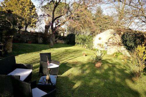 a yard with chairs and a table with a guitar at CLAUDIA VACANZA TOSCANA - Appartamento Melograno -10 min da Siena in Sovicille