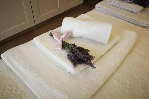 a white towel with a pink ribbon on it at CLAUDIA VACANZA TOSCANA - Appartamento Melograno -10 min da Siena in Sovicille