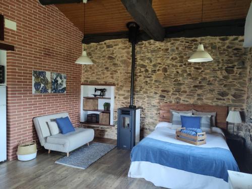 - une chambre avec un lit, une chaise et un mur en briques dans l'établissement MINI PICONEIRO II, à Pravia