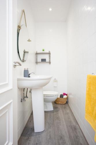 a white bathroom with a sink and a toilet at Apartamento Río Maior in Muros