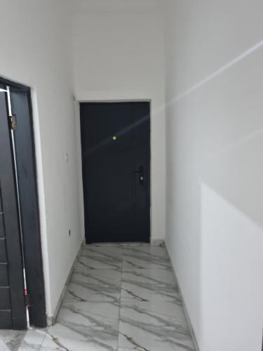 a hallway with a black door and a marble floor at nanas@TEMA C11 in Tema