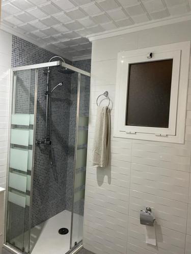 a bathroom with a shower and a television on the wall at MALVARROSA BEACH FAMILIAR in Valencia