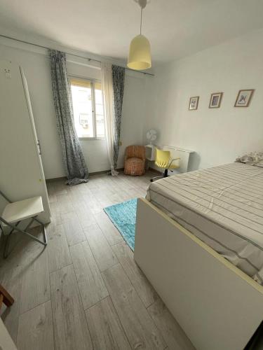 a bedroom with a large bed and a window at MALVARROSA BEACH FAMILIAR in Valencia