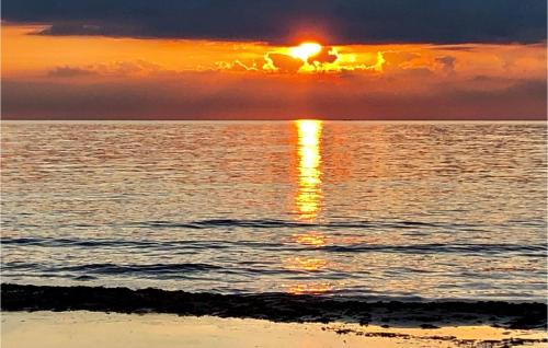 a sunset over the ocean with the sun setting at 1 Bedroom Stunning Home In Grimsholmen in Grimsholmen