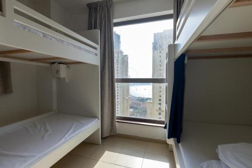 a room with two bunk beds and a window at Travel Hub Premium in Dubai