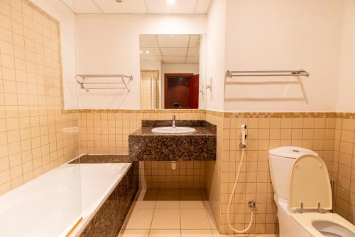 y baño con bañera, lavabo y aseo. en Travel Hub Premium, en Dubái