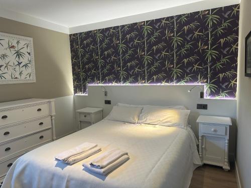 a bedroom with a bed with two towels on it at Apartamentos Alquitara in Potes