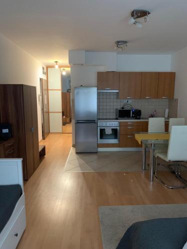 eine Küche mit einem Kühlschrank aus Edelstahl und einem Tisch in der Unterkunft Corvin Fontana Apartment in Budapest