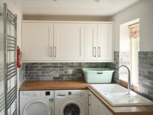 a kitchen with a washing machine and a sink at Albion Cottage in Whitby