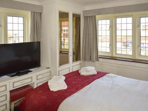 a bedroom with a tv and a bed with towels at Albion Cottage in Whitby